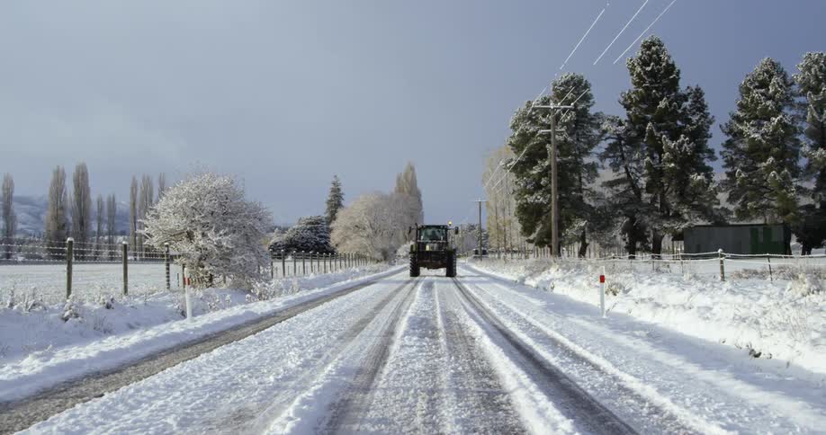 Vehicle driving down a snowy country road
