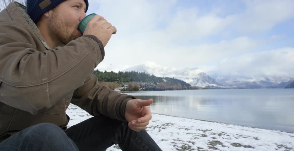 A person drinking something by the fire