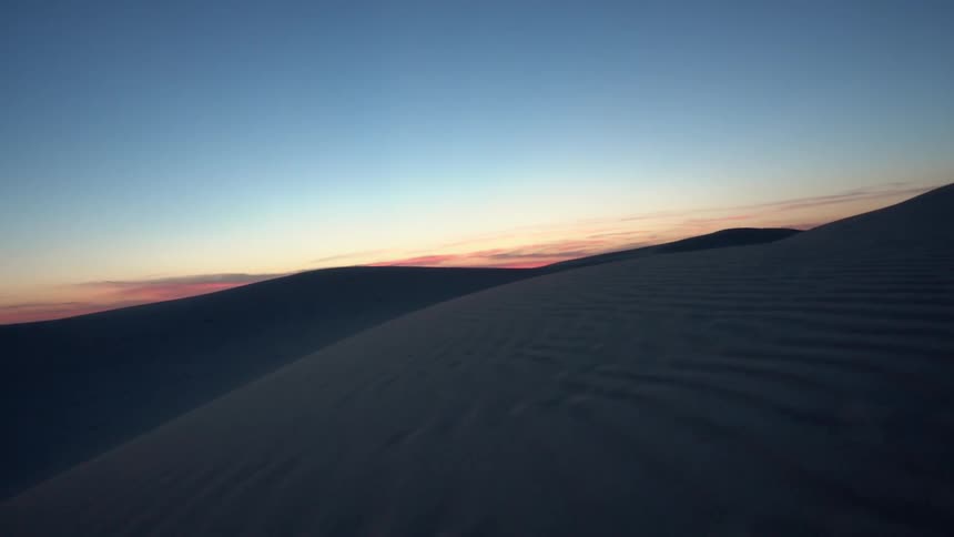 Moving over a desert at sunset