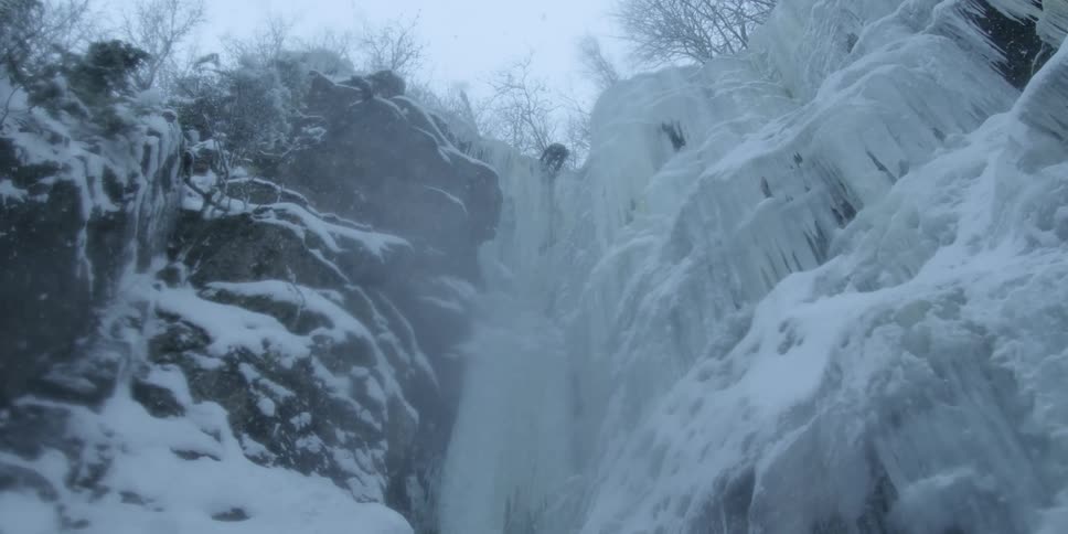 The rock climber is nearly to the top of the cliff