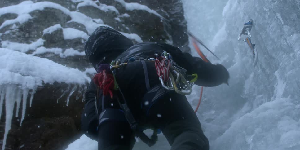 A person climbs up a mountain through the snow