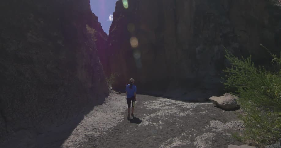 A woman hikes between mountains