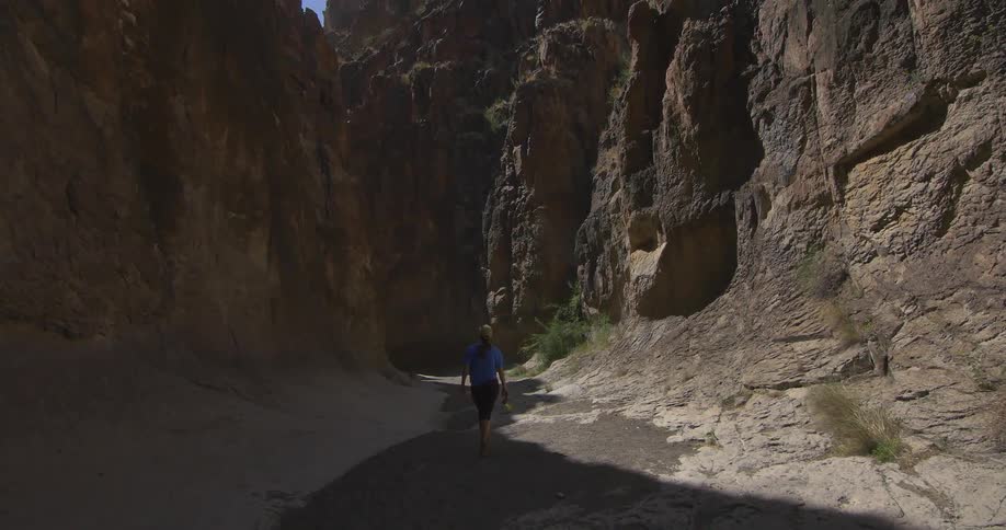A person walks between rock formations