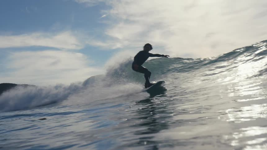 A man surfs a large wave in the ocean