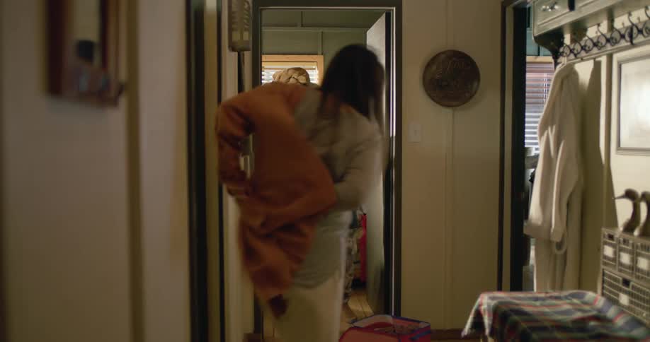 A family rushes to get dressed as the son walks around playing a portable gaming console