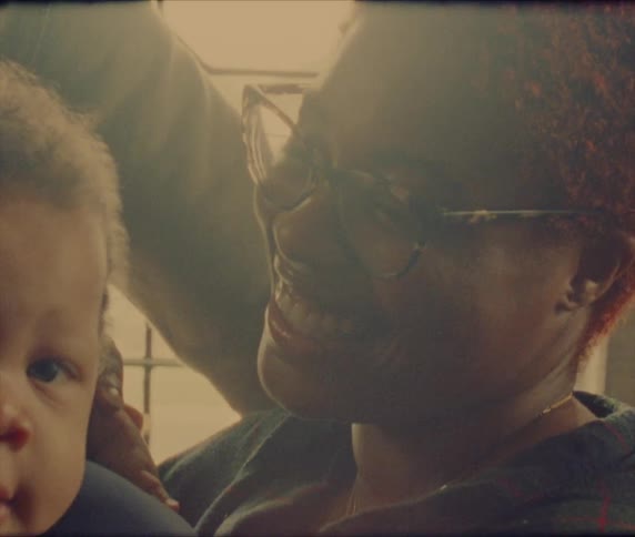 A woman is holding a baby boy and smiling and laughing