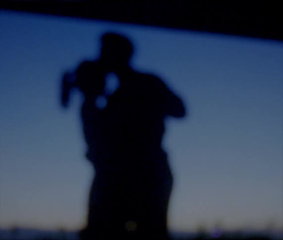 Man spins woman under his arm as they dance outdoors silhouetted by the sky