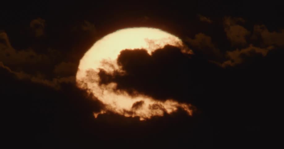 Silhouette of dark clouds hanging in front of the rising sun at morning