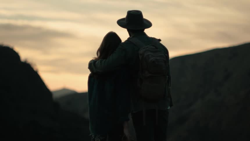 A man and woman watch the sunset together