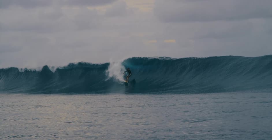 A man is surfing on a large wave
