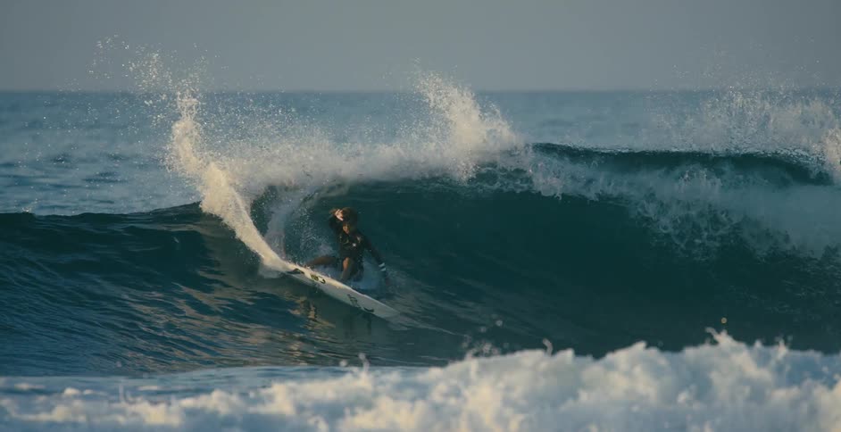 A surfer rides a big wave as water splashes around him
