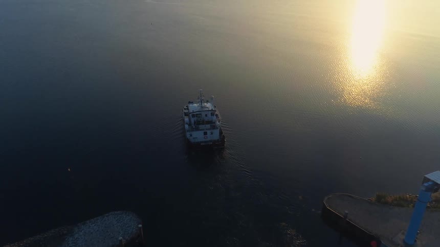 People move around on boat leaving lagoon passing ocean surface reflecting bright sunlight