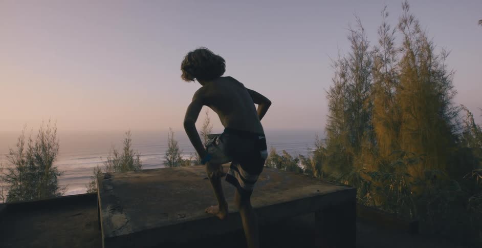 Child jumping onto table near ocean