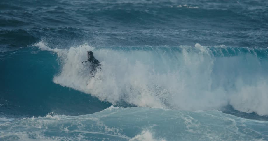 A person surfing on a big wave in the ocean