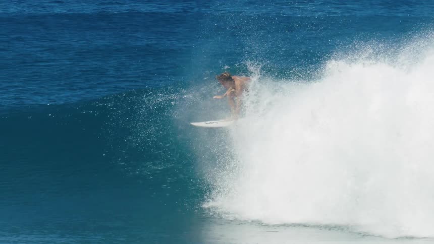 Two surfers are riding a big wave as one goes under when the wave covers him
