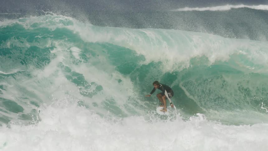 Surfer rides wave as it crashes over him