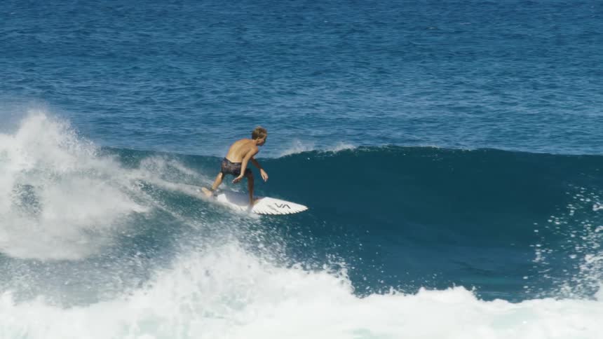 A surfer is riding a big blue wave