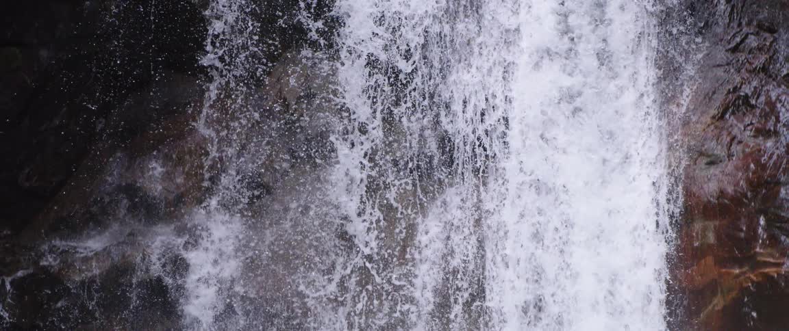 Waterfall cascades down cliffside in the forest