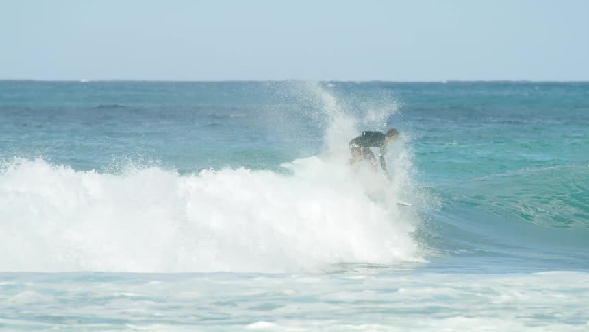 A man does flips as he surfs in the ocean