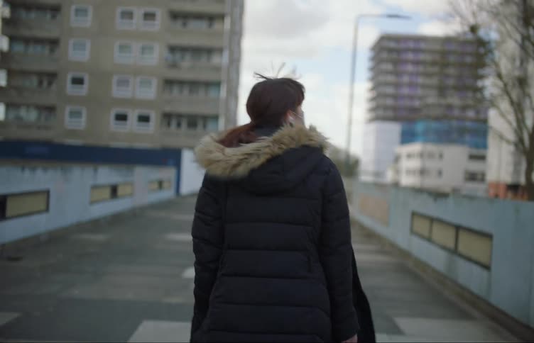 A woman is walking in a downtown city in winter