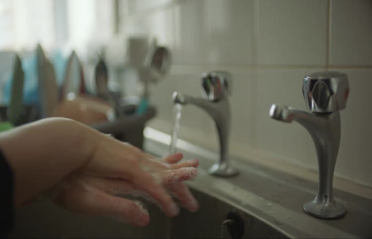 A person is washing their hands with soap and water