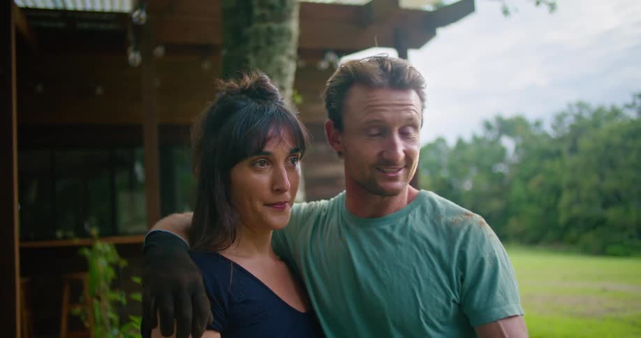 A man and woman hugging and talking outdoors