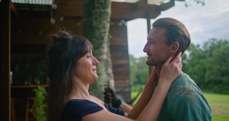 A wife brushes her husbands hair and they kiss