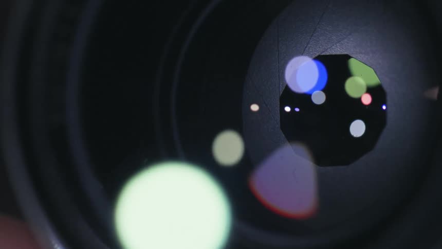 The lights reflect on the camera lens as it takes photographs