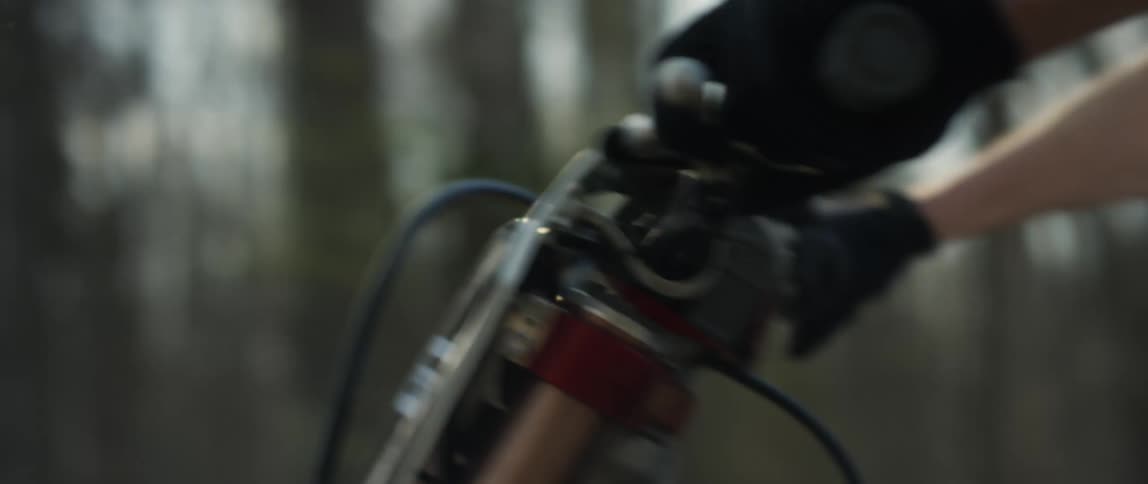 A man drives a motorcycle through a forest