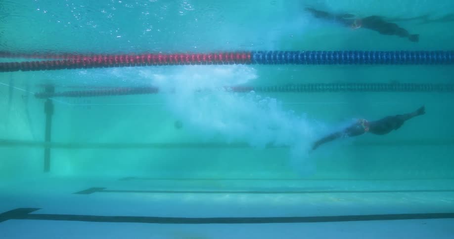 A person is swimming underwater in a pool