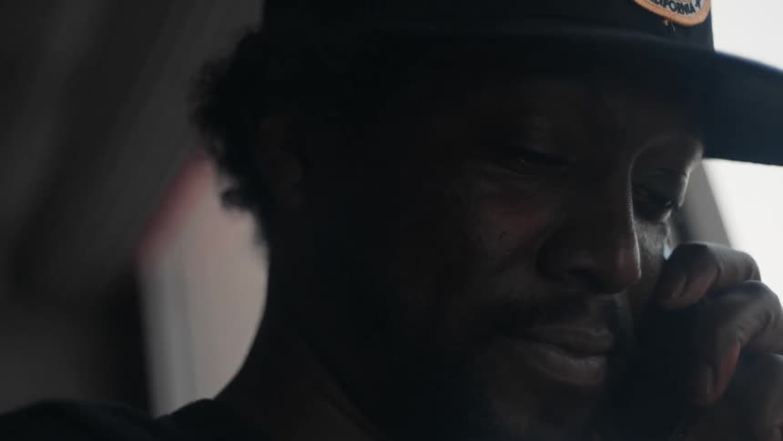 A man is next to a window and talking on his cellphone