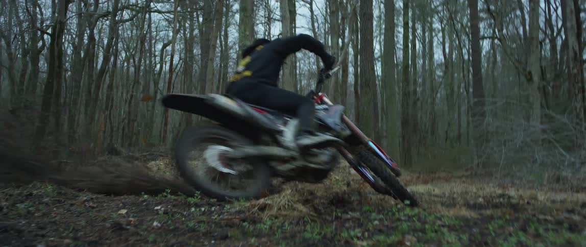 Person riding a dirt bike in a circle in the woods