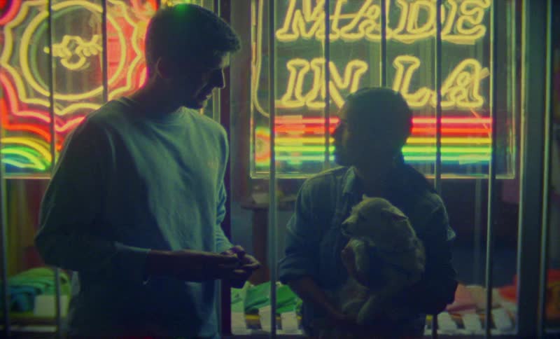 A view of two people talking while holding a dog
