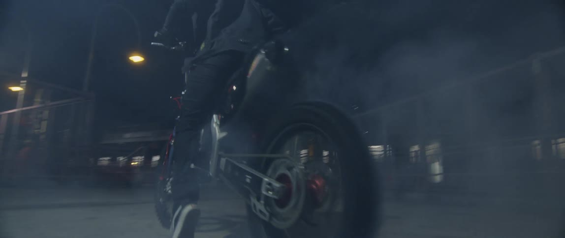 Man riding a motorcycle burns tires on the asphalt on a cloud of smoke