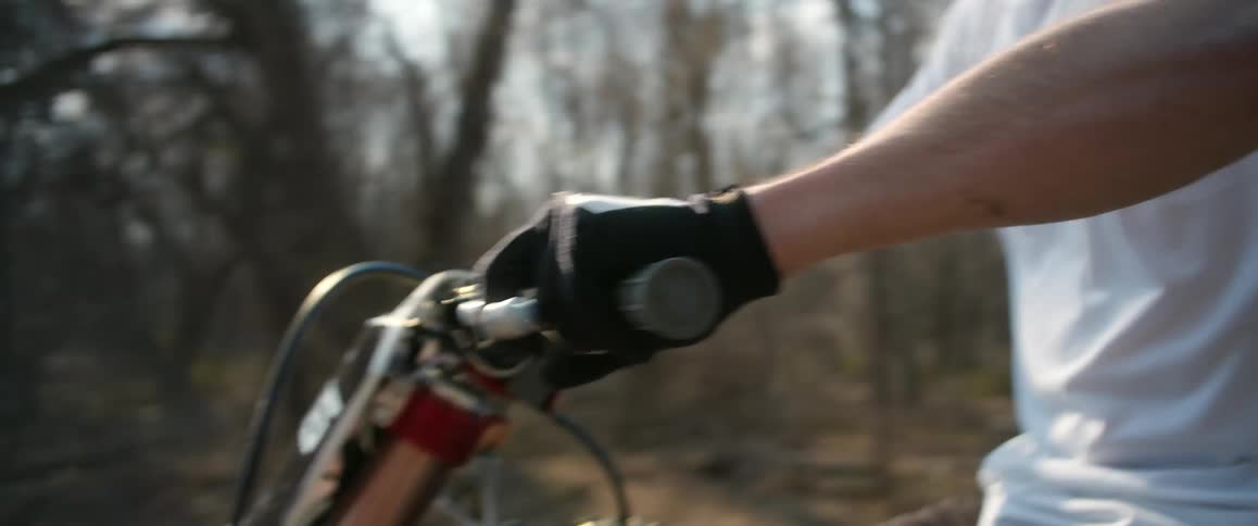 A man is riding his dirt bike past the woods