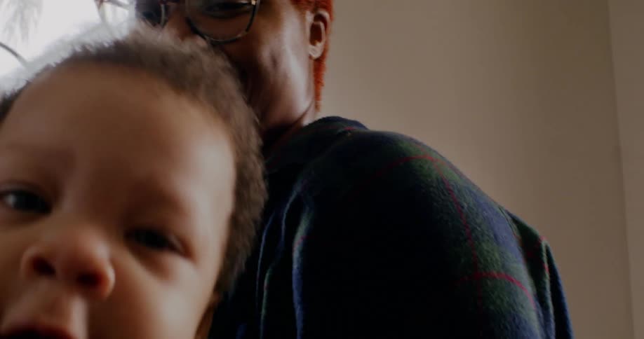 A mother is holding her child who is moving around