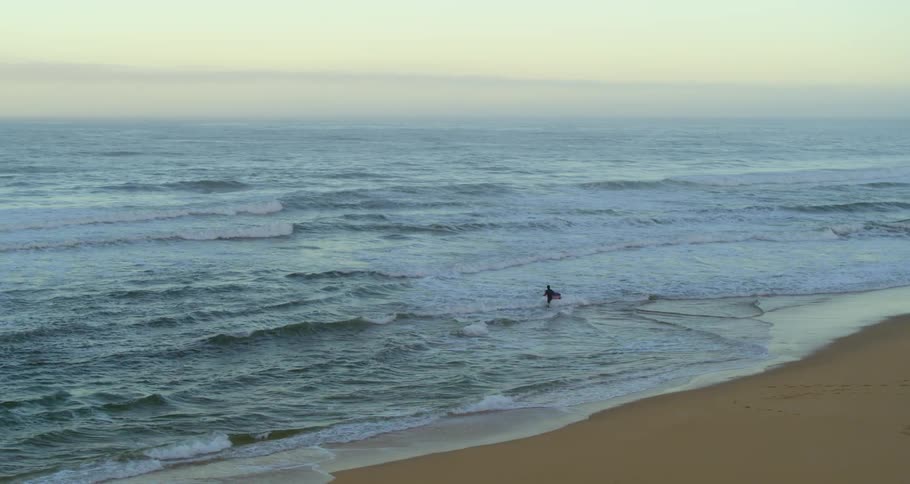 Surfer walking into water