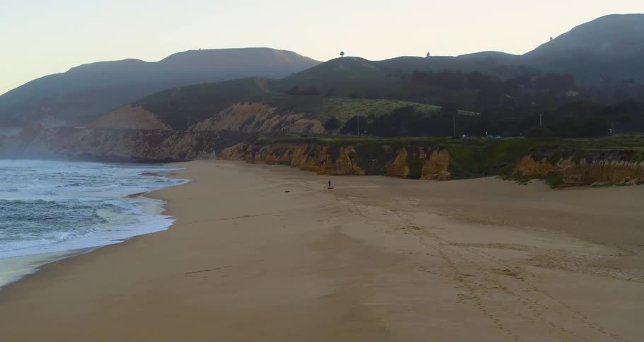 An aerial view of a beach and a road next to it