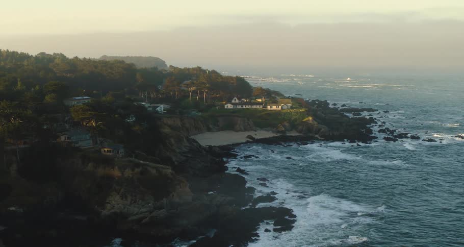 Aerial view of houses and lighthouse on a small waterfront town near the ocean at morning coastal