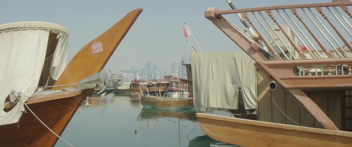 Large wood boats moored at a dock during the day