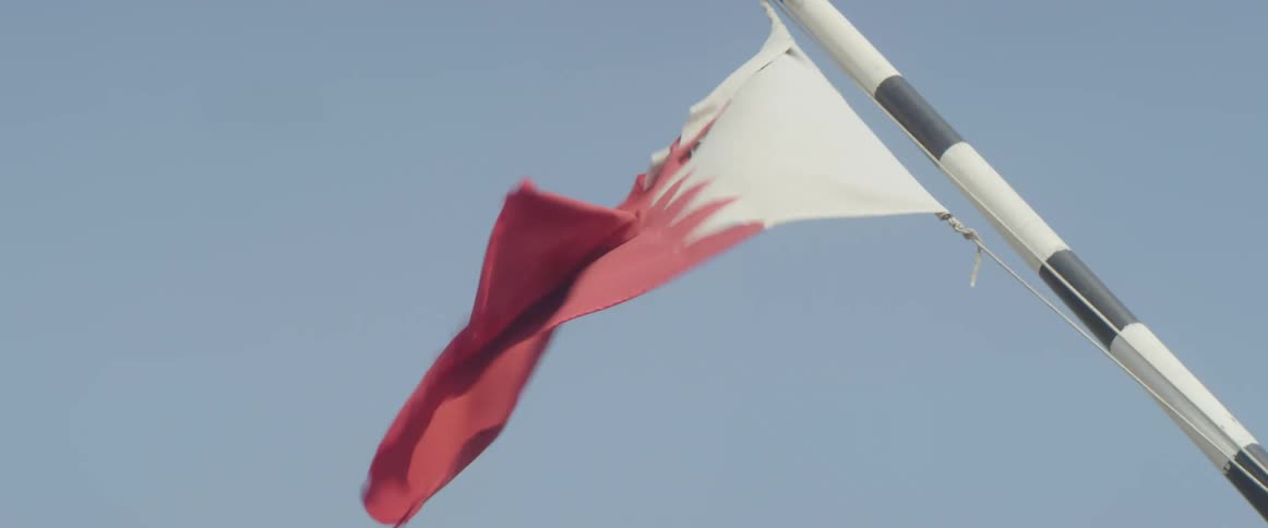 A red and white flag billowing in the wind on a clear day