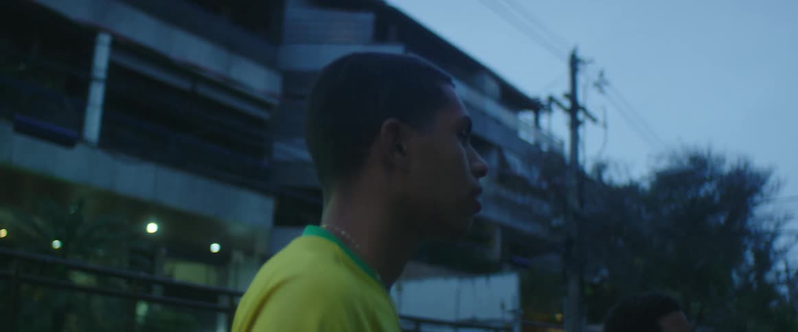 Youths stand talking in street with a soccer ball