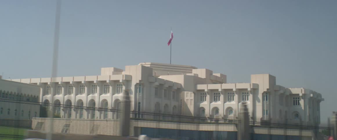Traveling past a large white government building with a flag flying high