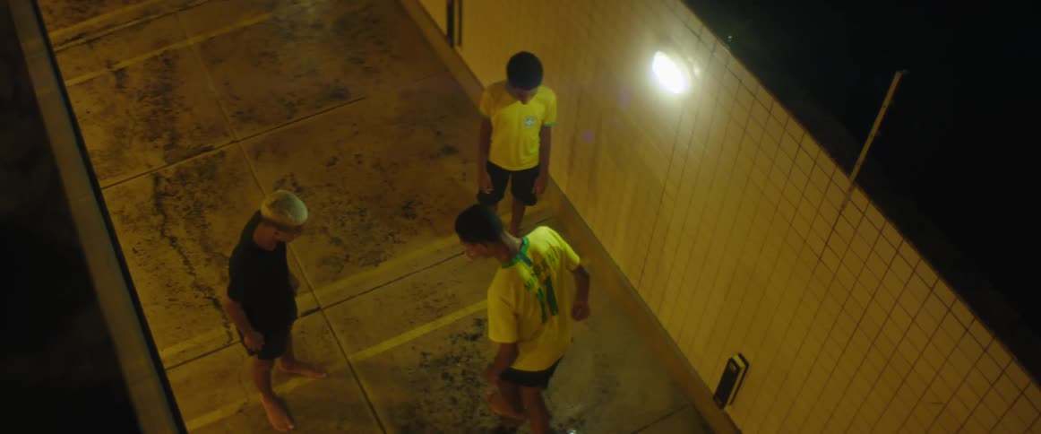 A group of people kicking a soccer ball at night