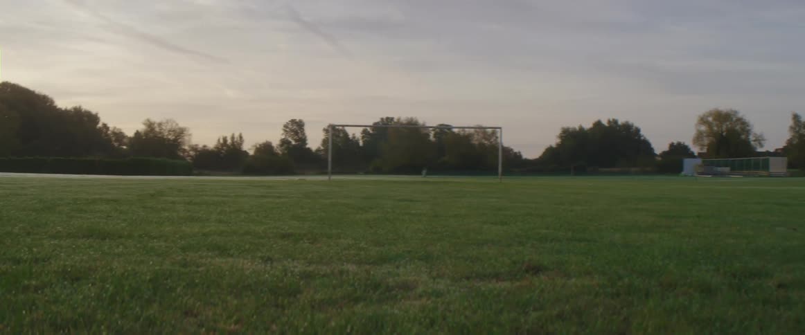 The sun is setting in the horizon of an open field