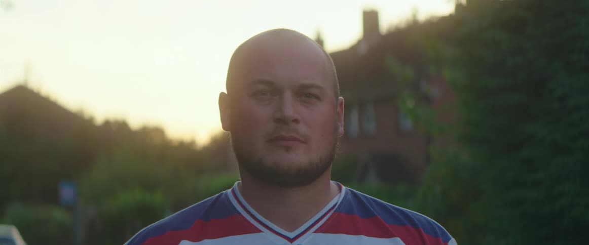 A man is standing outdoors in spring while the sun is setting
