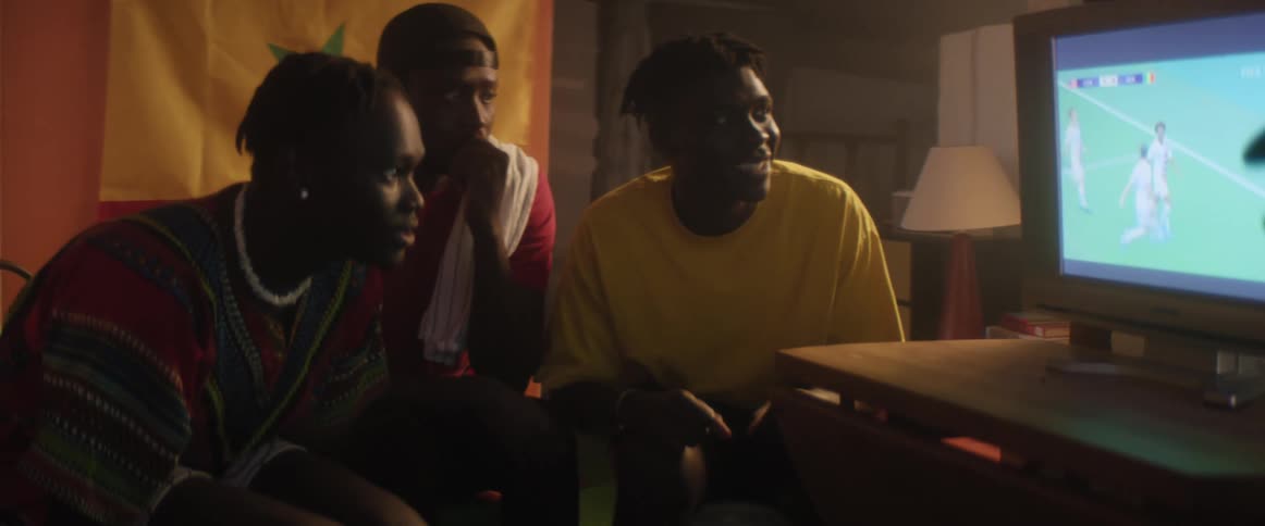 Group of friends attentively looking at a soccer game on a television at home