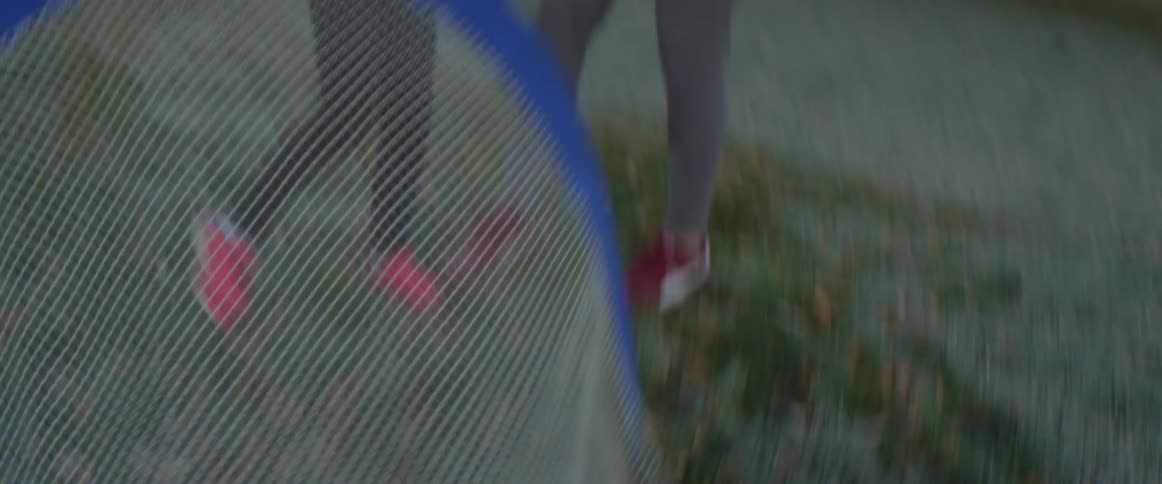 Blonde girl playing with a ball in the backyard at home near her father