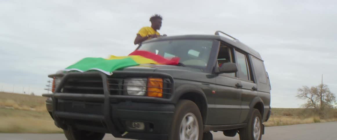 Black male hanging out of car