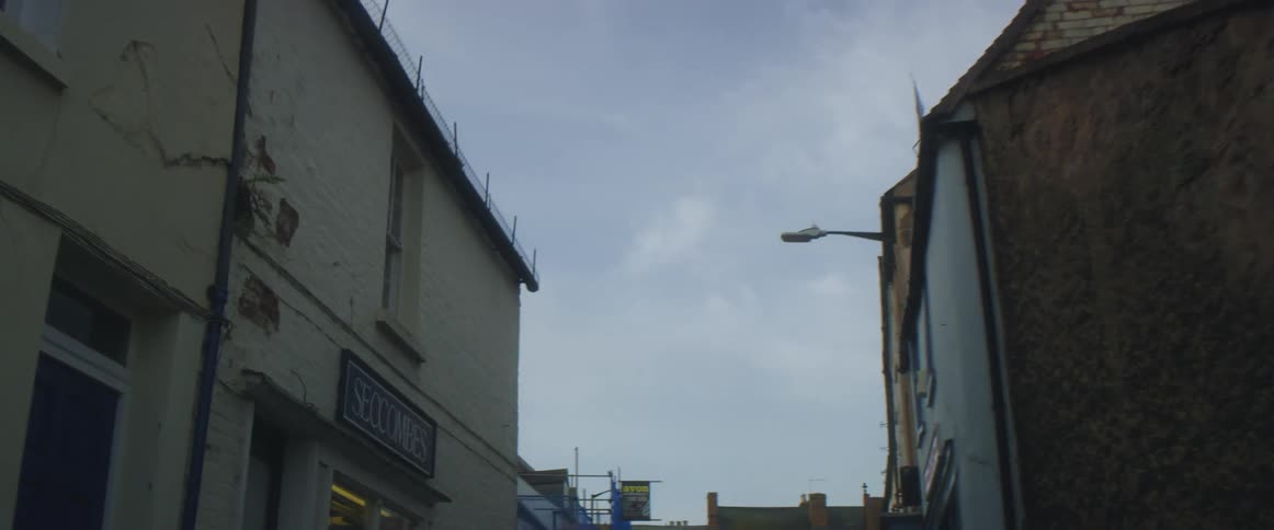 A street lined with stores and construction happening on one building